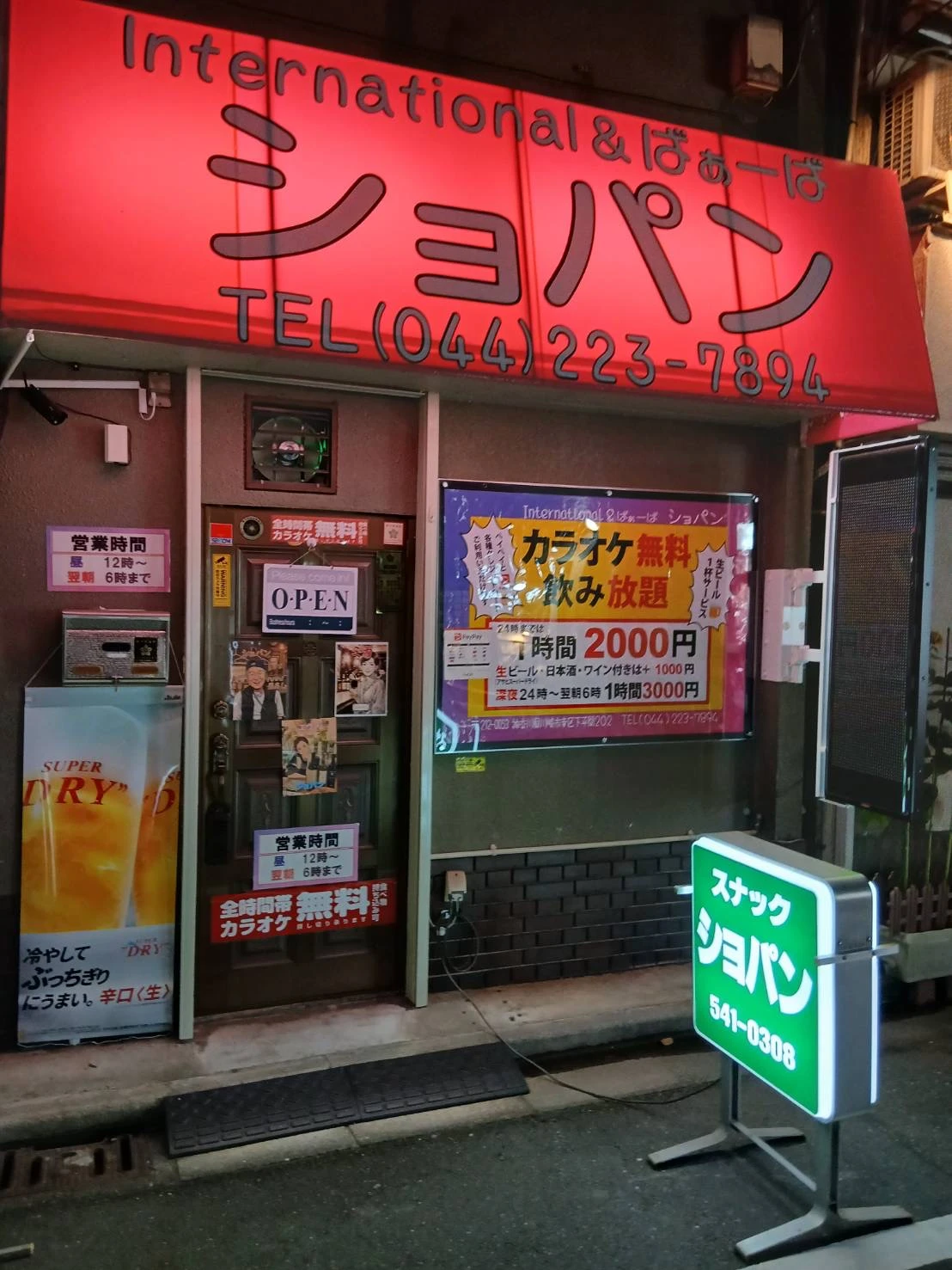 夜のスナック ショパン外観。赤い庇看板が灯る